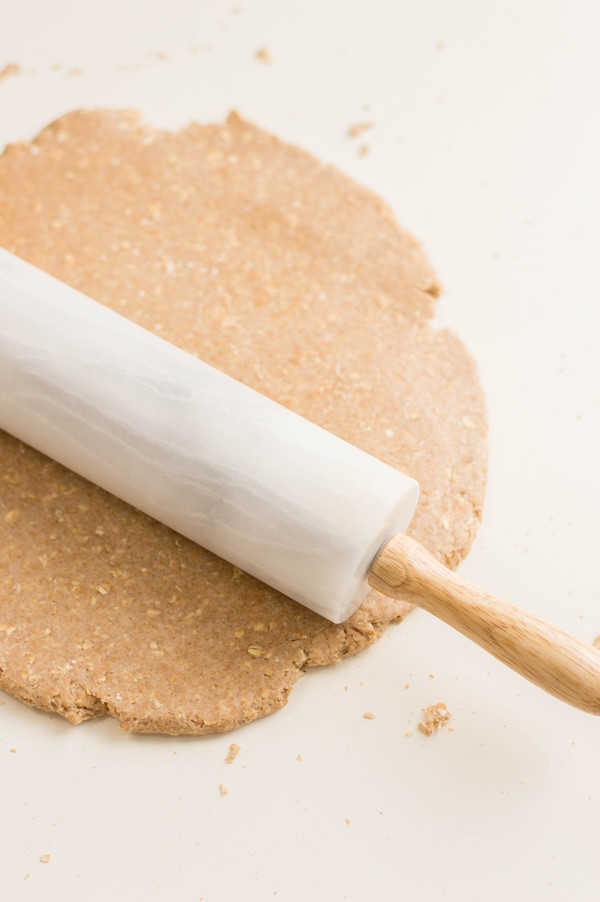 Rolling out the dough with a white marble rolling pin