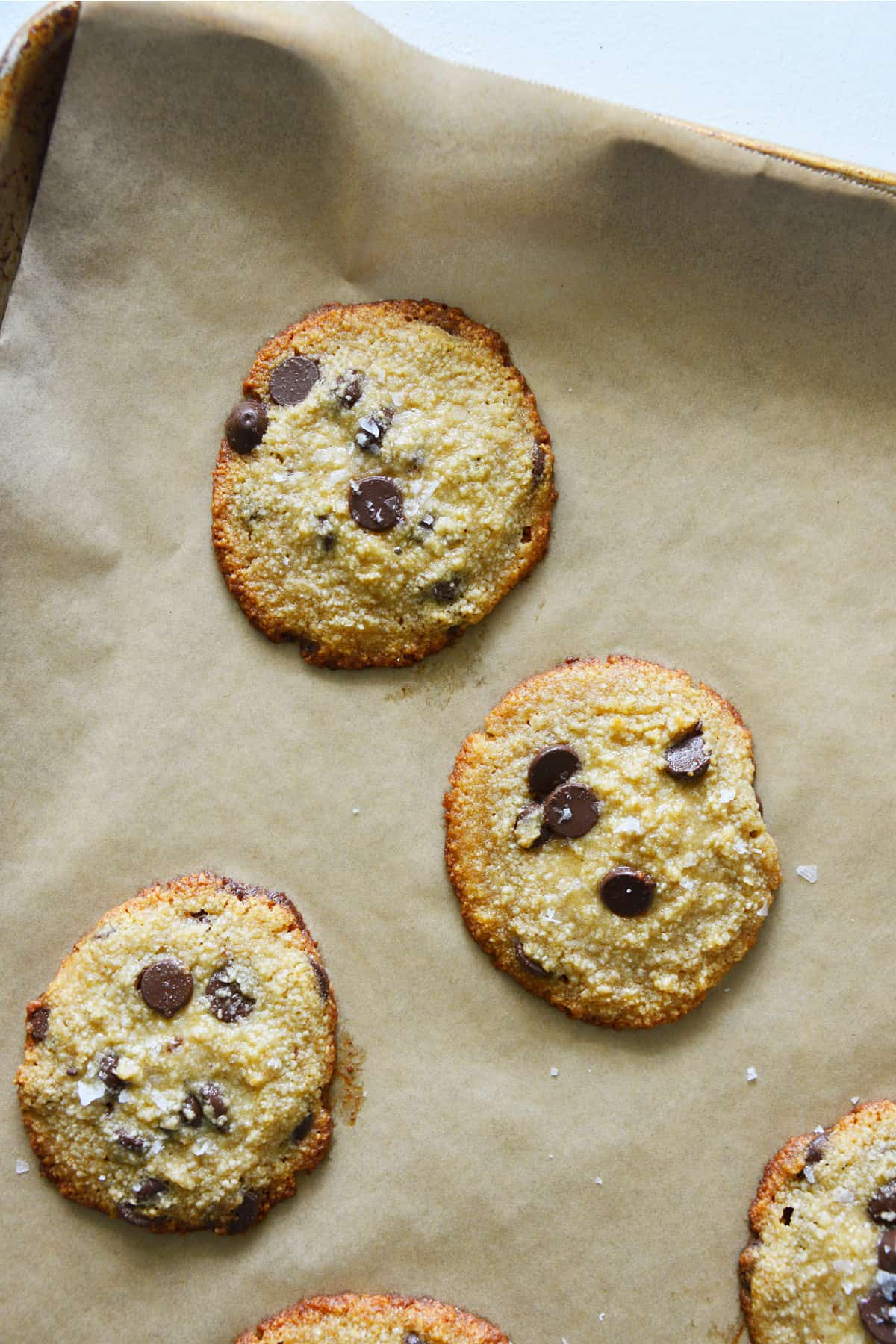 Bake the cookies one tray at a time until they’re golden around the outside but still look a touch doughy in the center, about 9 minutes